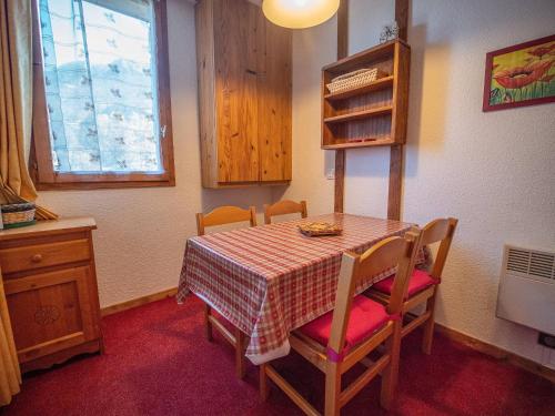 - une table à manger avec des chaises et un tissu de table en damier dans l'établissement Appartement cosy, 100m des pistes, balcon, casier à skis, quartier calme, proche commerces - FR-1-356-327, à Valmorel