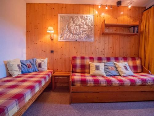 Cette chambre comprend deux lits et un canapé. dans l'établissement Valmorel : Appart 2 pièces au pied des pistes, animaux admis - FR-1-356-285, à Valmorel