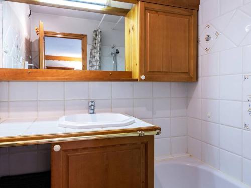 une salle de bain avec un lavabo, un miroir et une baignoire dans l'établissement Appartement 2 chambres avec balcon et casier à skis à Méribel - FR-1-355-41, à Méribel