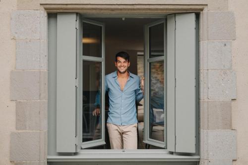 a man is standing in a window at La Demeure de la Cité by Jean Bacou in Carcassonne
