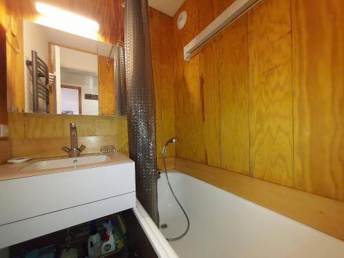 La salle de bains est pourvue d'un lavabo et d'une baignoire avec douche. dans l'établissement Appartement 2 pièces à Valmorel, proche pistes et commerces, équipé, wifi, non-fumeur - FR-1-356-310, à Valmorel