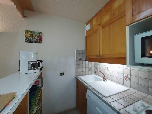 une petite cuisine avec un évier et un micro-ondes dans l'établissement Charmant 2P à Valmorel, balcon, proche pistes, animaux ok - FR-1-356-339, à Valmorel