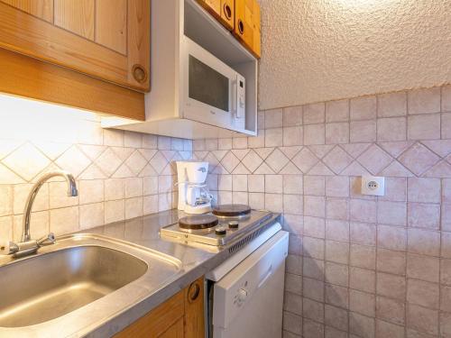 - une cuisine avec un évier et une cafetière sur un comptoir dans l'établissement Studio divisible 4pers, au pied des pistes, animaux admis - Valmorel - FR-1-356-276, à Valmorel