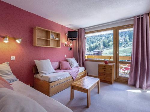 une chambre avec un lit, un canapé et une fenêtre dans l'établissement 2P au pied des pistes, 2 balcons, lumineux, proche école de ski et commerces, animaux permis - FR-1-356-301, à Valmorel