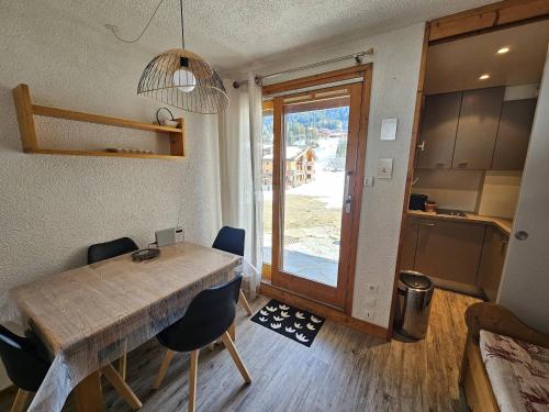 une cuisine et une salle à manger avec une table et des chaises en bois dans l'établissement Valmorel - Appartement cosy 4 pers, accès direct pistes - FR-1-356-315, à Valmorel