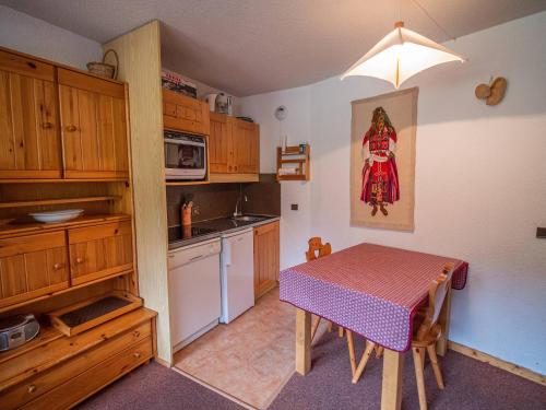 une petite cuisine avec une table et un chiffon rouge dans l'établissement Valmorel : 3P lumineux, pied des pistes, proche ESF, balcon sud-est - FR-1-356-319, à Valmorel