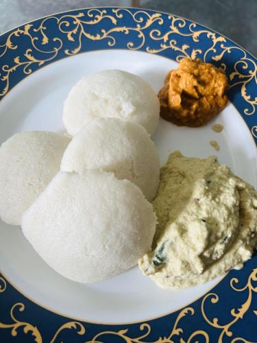 ein Teller mit Essen mit Reis und Dip darauf in der Unterkunft WM Resorts in Pooppara