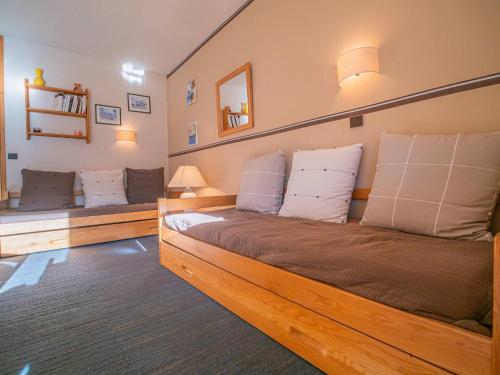 - une chambre avec un grand lit en bois et 2 bancs dans l'établissement Appartement cosy avec balcon - 50m des pistes - Hameau Crève-Cœur (5 pers) - FR-1-356-346, à Valmorel