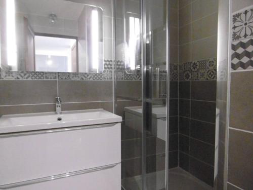 une salle de bain avec une douche, un lavabo et un miroir dans l'établissement Appart cosy au pied des pistes, balcon, casier à skis - FR-1-355-197, à Les Allues