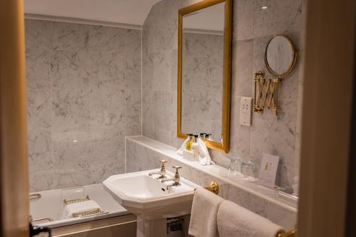 a white bathroom with a sink and a mirror at The Red Lion Hotel in Hillingdon