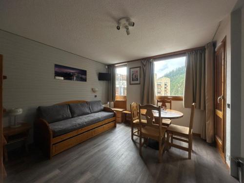 un salon avec un canapé et une table dans l'établissement Studio fonctionnel au pied des pistes avec balcon - FR-1-181-2316, à La Plagne Tarentaise