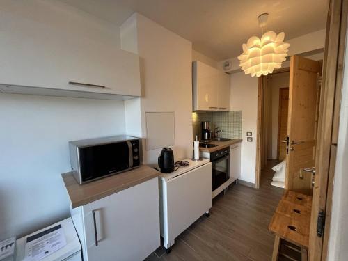 une cuisine avec un comptoir avec un micro-ondes dans l'établissement Charmant Appart 22m² - 1 Chambre - Proche Pistes et Commerces à Méribel Mottaret - FR-1-355-216, à Les Allues