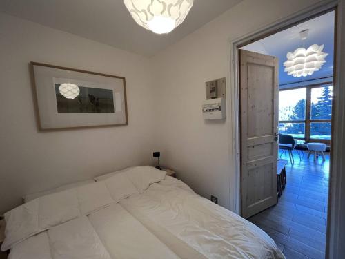 une chambre avec un lit blanc et une grande fenêtre dans l'établissement Charmant Appart 22m² - 1 Chambre - Proche Pistes et Commerces à Méribel Mottaret - FR-1-355-216, à Les Allues