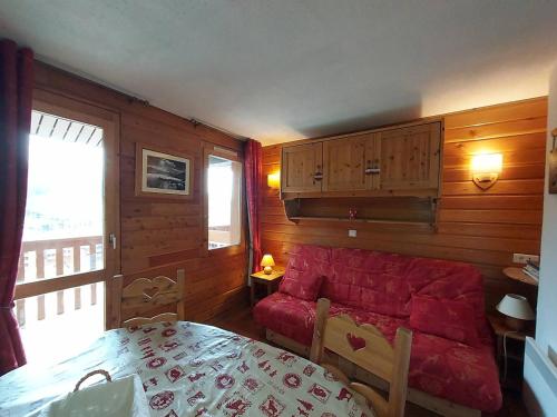 un salon avec un canapé rouge et une table dans l'établissement Studio divisible avec coin montagne, au pied des pistes, balcon, 4 pers - FR-1-356-427, à Valmorel
