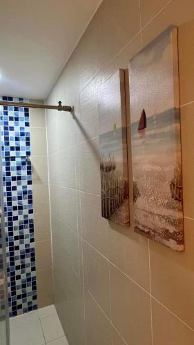 a bathroom with a shower with a painting on the wall at Heavens Den Staycation Pampanga in Lagundi
