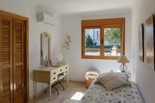 a bedroom with a bed and a desk and a mirror at BEACH VILLA with PRIVATE POOL in Palma de Mallorca
