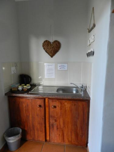 a kitchen with a sink and a heart on the wall at Brand Guesthouse in Colesberg