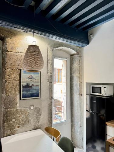 une cuisine avec une table blanche et une fenêtre dans l'établissement Le Bucolique - Cœur Vieille-ville d'Annecy, à Annecy