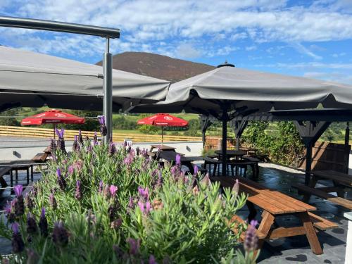 a patio with tables and umbrellas and flowers at The Swinside Inn in Keswick