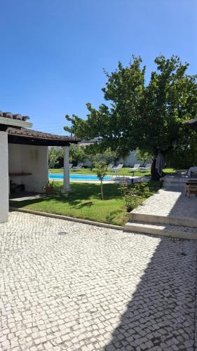a stone walkway in front of a house with trees at Casa do Patio - Très charmante villa 12 personnes 5ch avec piscine in São Bartolomeu