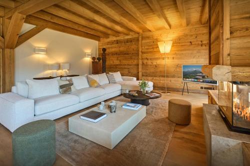 un salon avec un canapé blanc et une télévision dans l'établissement Chalet Piccolo - OVO Network, à Saint-Gervais-les-Bains