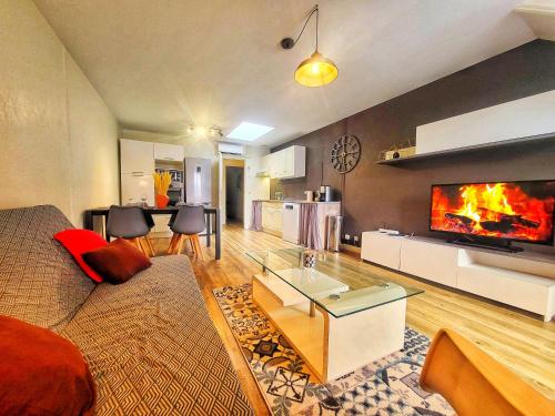 un salon avec un canapé et une cheminée dans l'établissement Appart in Py' - Charmant Appartement Climatisé plein centre Marcadieu, à Tarbes