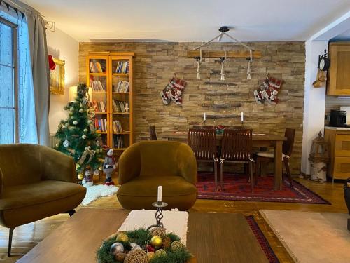 a living room with a table and a christmas tree at Snow White Chalet in Brezovicë