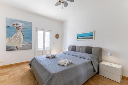 a bedroom with a bed and a painting on the wall at Villa Maria con piscina riscaldata in Santa Maria Del Focallo