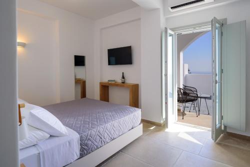 a white bedroom with a bed and a sliding glass door at Elia Pyrgos in Pyrgos