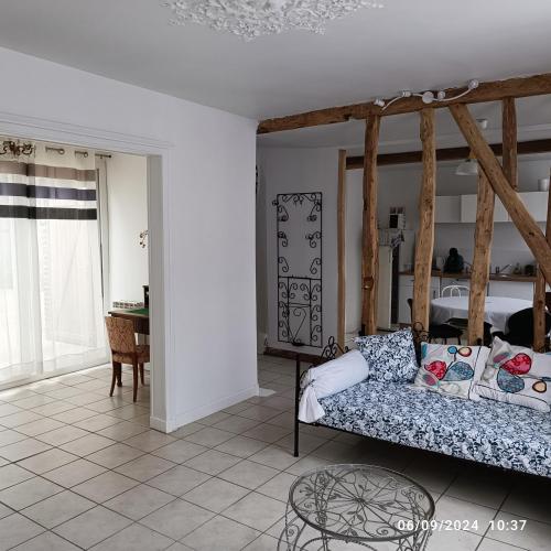 un salon avec un canapé et une table dans l'établissement Aux volets bleus, à Conty