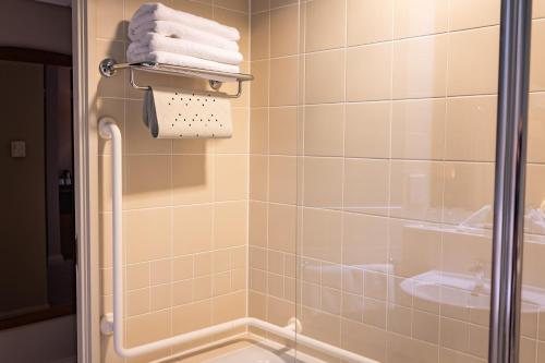 a bathroom with a shower with white towels at The Red Lion Hotel in Hillingdon