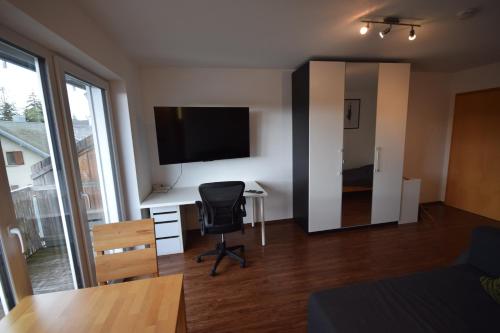 a room with a desk with a computer and a television at Nestwerk Komfort R23-12 - Balkon, Arbeitsplatz & Zentrumsnah in Biberach an der Riß
