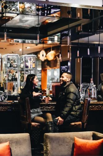 a man and a woman sitting at a bar at Renaissance Santiago by Marriott in Santiago