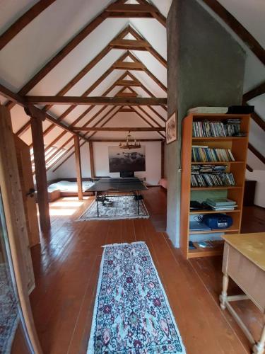 an attic room with a table and a rug at Snow White Chalet in Brezovicë