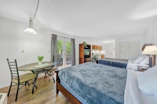 a bedroom with two beds and a table and a dining room at Halesford Harbour Resort - Smith Mountain Lake in Moneta
