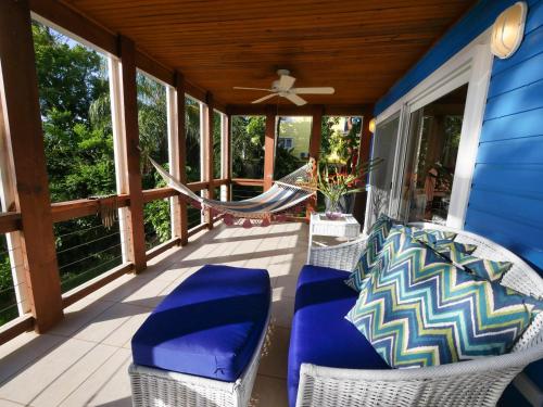 a porch with chairs and a hammock on a house at Incredible Ocean Views From Both Sides Of This Hill Top Home, in West Bay