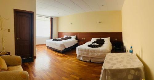 a hotel room with two beds and a table and chairs at Hostal Alvasar in Copacabana