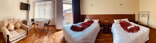 a bedroom with two beds and a couch at Hostal Alvasar in Copacabana
