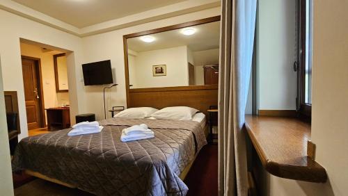 a hotel room with a bed with towels on it at Jasny Dwór in Polanica-Zdrój