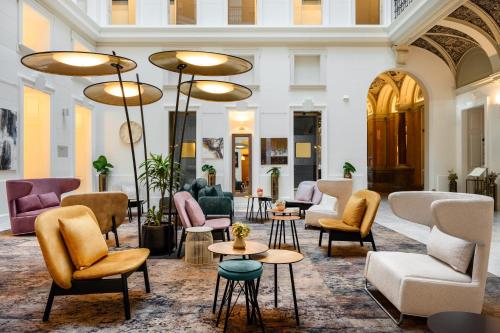 a lobby with couches and chairs and tables at Hotel Moments Budapest by Continental Group in Budapest