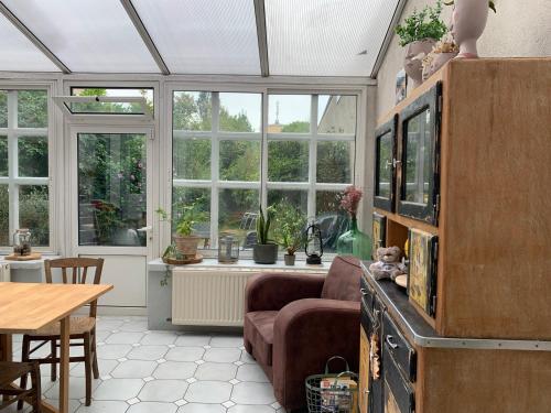 - un salon avec un canapé, une table et des fenêtres dans l'établissement Chambre chez Linda et Brice, à Châteauroux