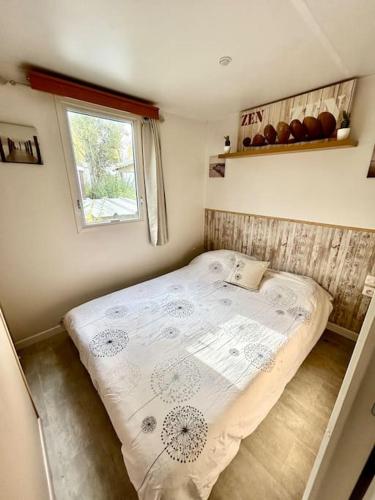 - un petit lit dans une petite chambre avec fenêtre dans l'établissement Mobil home à la tamarissière, au Grau-dʼAgde