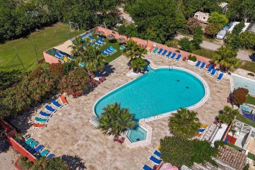 - une vue sur la piscine avec des chaises et un complexe dans l'établissement Mobil home à la tamarissière, au Grau-dʼAgde