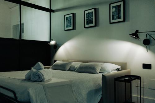 a bedroom with a bed with a white blanket and pillows at La Portesina Mantova in Mantova