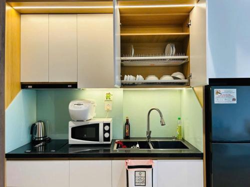 a small kitchen with a sink and a microwave at Ben's Homestay Ecopark - Landmark L2 in HÆ°ng YÃªn