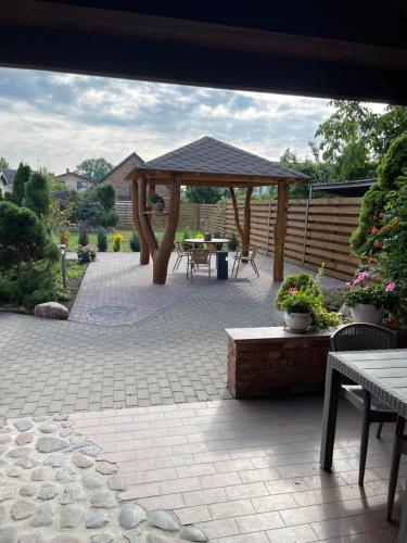 a patio with a gazebo and a table at Akmenine Kerpe in Marijampolė