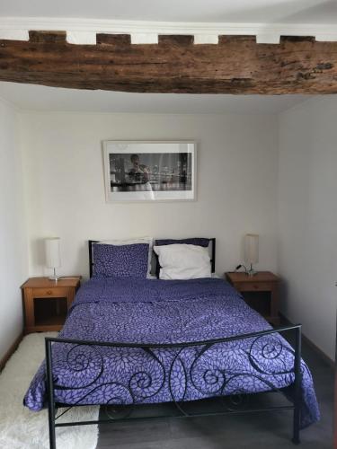 une chambre avec un lit avec une couette violette dans l'établissement Gîte Studio Armen 3 Masson de Morfontaine, à Bar-sur-Aube