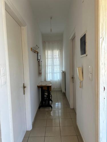 a hallway with a table and a window in a room at Family Apartment in Potamos Kythira in Potamós