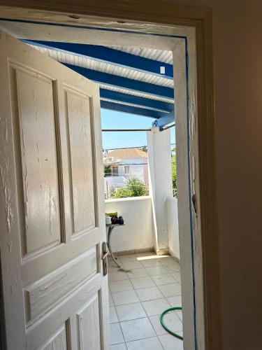 an open door to a balcony with a blue ceiling at Family Apartment in Potamos Kythira in Potamós