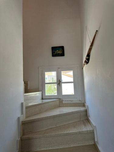 a room with stairs with a window and a door at Family Apartment in Potamos Kythira in Potamós